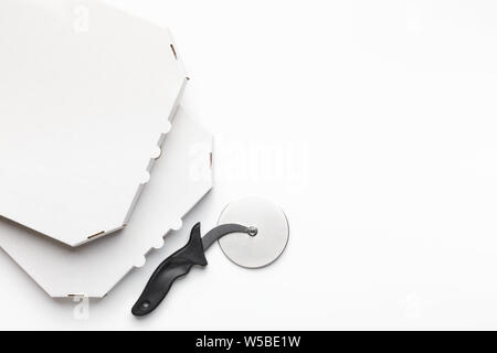 Blank cardboard boxes and pizza cutter on white background Stock Photo