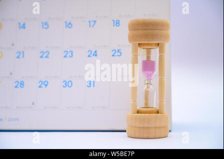 Hourglass with calendar ideas days elapsed time in each period and appointments or waiting Stock Photo