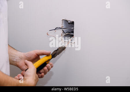 New electrical installation, socket box, switch and electrical cables on wall, renovation under construction Stock Photo