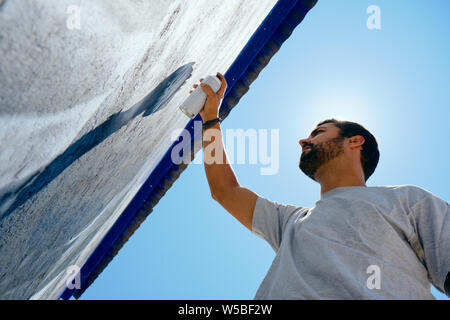 Man Painting Graffiti Along The Camino de Santiago Stock Photo