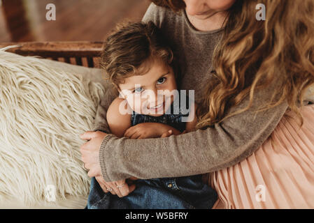 Close up portrait of young girl smiling while mother holds her Stock Photo