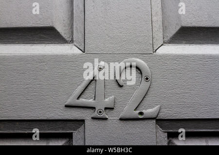 Elegant grey house number 42 with the forty two in the same colour as the wooden front door