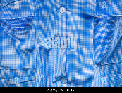 Blue checkered shirt which is typical design in the UK for female domestic, social care and school uniform. Stock Photo