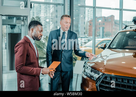 Serious businessman choosing a new suitable car. Stock Photo