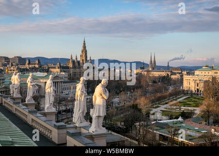 Statues of famous scientists on the roof of the Natural History Museum view with Parliament and the City Hall as a beautiful cityscape in Vienna Stock Photo