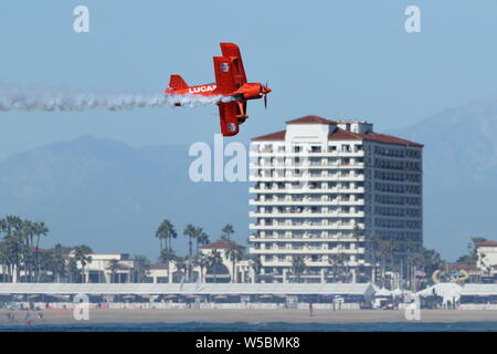 The Lucas Oil 'Super Stinker' red bi-plane flies along the coast during the Great Pacific Airshow in Huntington Beach, California on October 19, 2018 Stock Photo