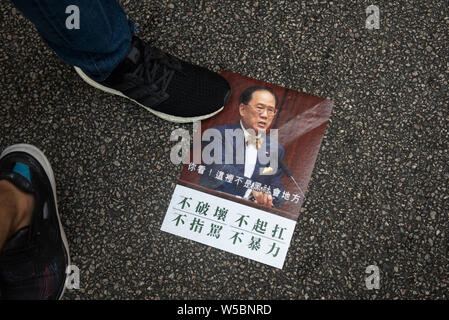 A protester steps on a placard illustrating former Hong Kong Chief Executive Donald Tsang during the demonstration.Thousands of protester continue their weekly anti-government protest demanding the government to fully withdrawal the extradition bill and set up an independent commission to look into the issues of the police using disproportionate force against protester and linking up with local gang members to attack protesters last week. The protest took place in the Yuen Long district where protesters were brutally attacked by a mob of gang members dressed in white last week. Stock Photo