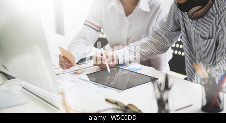 Young professional business team discussing the project while working on the tablet Stock Photo