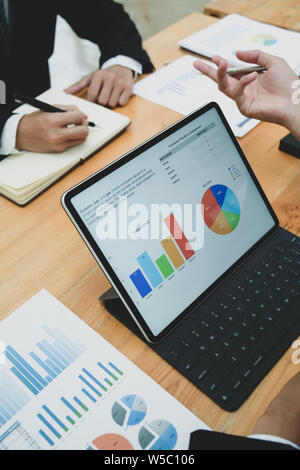 Young business team is discussing project and working on a tablet in office Stock Photo