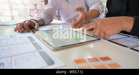 UX Designer team sketch mobile app developer outlines an app on tablet for web mobile smart phone Stock Photo