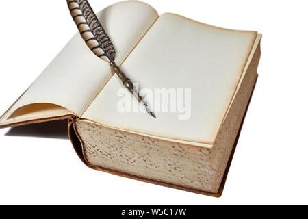 Large vintage book opened to a blank page with a quill pen laying on top of it isolated on white with shallow depth of field Stock Photo