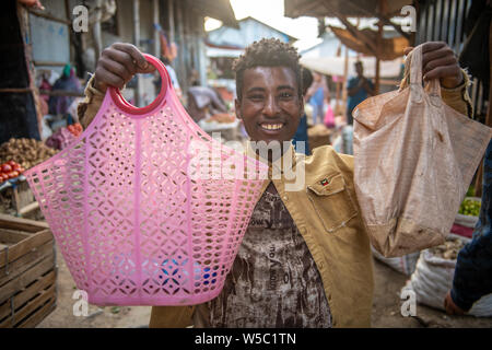 A smiling man holds up two bags from the markets in Mekele, Ethiopia Stock Photo