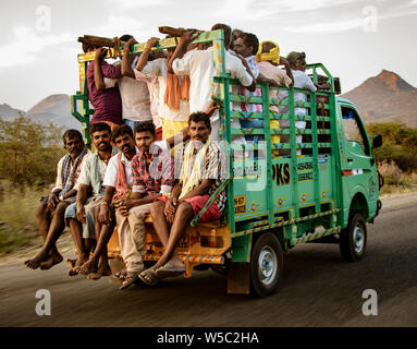 Kochi, India, Mar 4, 2018, Men ride in truck - Men crowd into the back of a truck to be transported to work in the fields Stock Photo