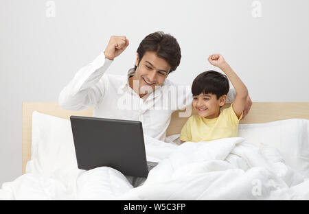 Man with his son working on a laptop Stock Photo