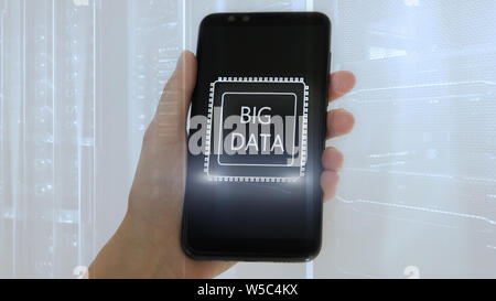 Woman Hand holding mobile phone. Server room background. Inscription on a virtual screen: Big Data. Double exposure. Stock Photo