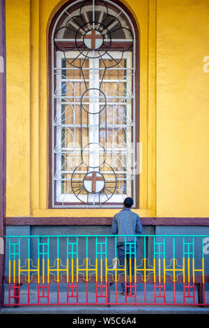 A man standing in front of a window, Debre Berhan, Ethiopia Stock Photo