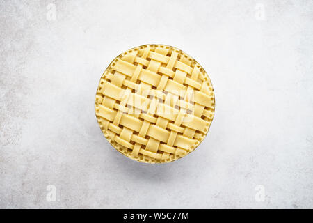Raw unbaked apple pie with lattice top on light gray concrete background. Top view. Space for text. Stock Photo