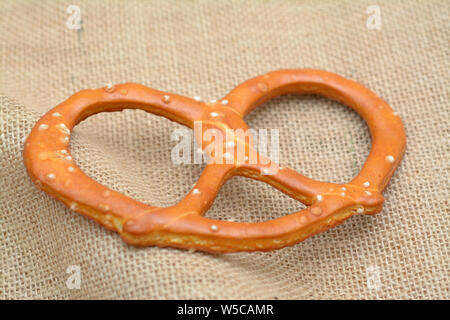 single crispy pretzel  on burlap on table Stock Photo