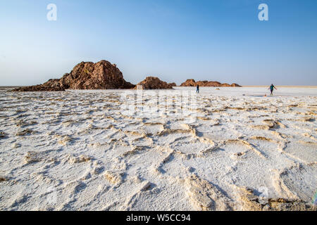 Tourist walk on salt flats in the Danakil Depression ,  Ethiopia Stock Photo