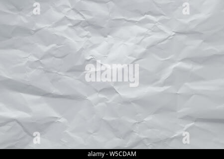 Gray crumpled paper background. Grey creased sheet page. Abstract rough texture, copy space. White wrinkled cardboard surface. Stock Photo