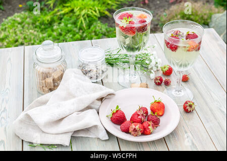 Champagne wine and strawberries. Summer food composition on a wooden table. Stock Photo