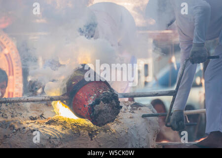 Molten Gold being poured into Buddha statue moulds Stock Photo