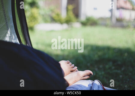 Details with the feet of a woman sleeping in a tent during a mountain trip Stock Photo