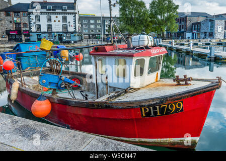 Little red fishing boat at Sutton Harbour, formerly known as Sutton Pool, original port of City of Plymouth at historic Barbican district. Devon. UK. Stock Photo