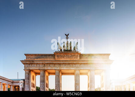 Brandenburg Gate monument as seen from Pariser Platz in Berlin, Germany during sunset on clear summer day