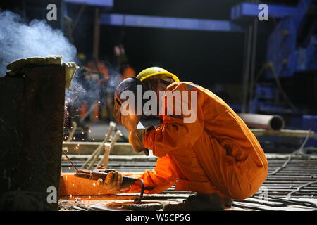 (190728) -- LUANG PRABANG, July 28, 2019 (Xinhua) -- A Chinese engineer works on the Luang Prabang Mekong River Super Major Bridge in the north of the Luang Prabang Ancient Town, a world heritage, some 220 km north of the Lao capital Vientiane, July 27, 2019. With the concrete beam of the last span over Mekong River put in place, the main section of Luang Prabang cross-Mekong River railway bridge has been completed on Sunday, seven months ahead of schedule.    The closure of the Luang Prabang Mekong River Super Major Bridge, one of the two cross-Mekong bridges along the China-Laos Railway, ind Stock Photo