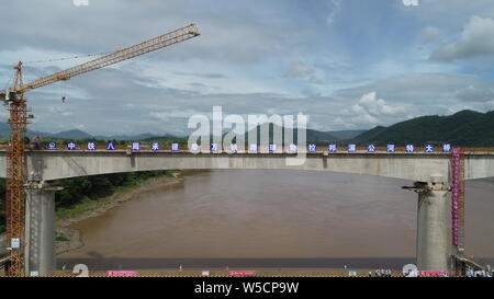 (190728) -- LUANG PRABANG, July 28, 2019 (Xinhua) -- Photo taken on July 28, 2019 shows the closed Luang Prabang Mekong River Super Major Bridge in the north of the Luang Prabang Ancient Town, a world heritage, some 220 km north of the Lao capital Vientiane. With the concrete beam of the last span over Mekong River put in place, the main section of Luang Prabang cross-Mekong River railway bridge has been completed on Sunday, seven months ahead of schedule.    The closure of the Luang Prabang Mekong River Super Major Bridge, one of the two cross-Mekong bridges along the China-Laos Railway, indi Stock Photo