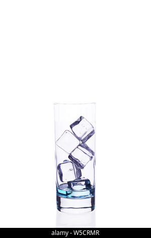 Glass beaker is filled with a blue cocktail ice cubes on a white background isolate. Stock Photo