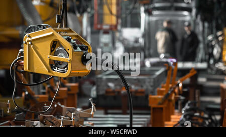 Welding machine on the background of people on the conveyor. Heavy production Stock Photo