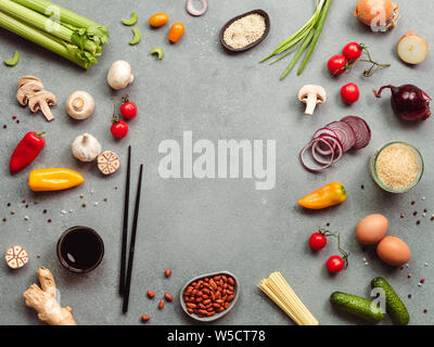 Asian food ingredients with copy space. Various of Chinese cooking ingredients and chopsticks on gray stone background. Asian food concept. Copy space for text. Top view or flat lay.