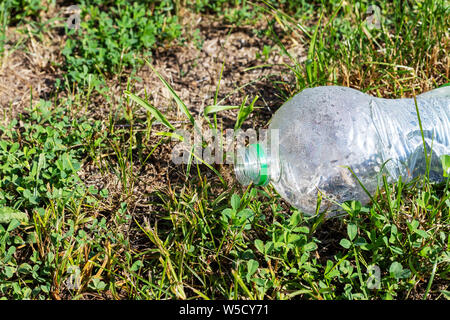 Plastic packaging in the natural environment. Empty used dirty plastic bottles. Environmental pollution. Used plastic waste packaging. Environmental Stock Photo