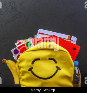 Yellow school backpack with accessories on black background Stock Photo