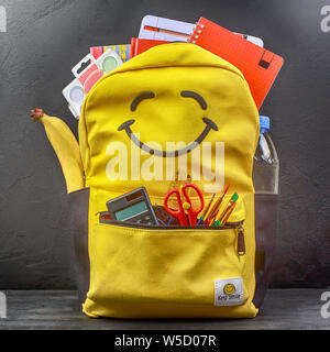 Yellow school backpack with accessories on black background Stock Photo