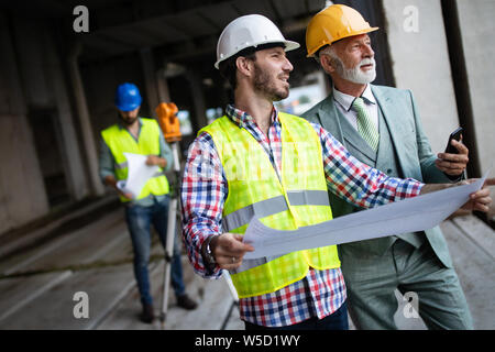 Engineer and construction site manager dealing with blueprints and plans Stock Photo
