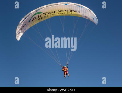 Tandem paraglider coming into land at La Caleta beach, Costa Adeje Stock Photo