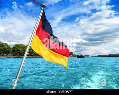 German flag on the stern of a ship sailing on a river Stock Photo