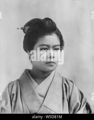 [ 1890s Japan - Japanese Woman in Kimono ] —   Woman in kimono and traditional hairstyle.  From a series of glass slides published (but not photographed) by Scottish photographer George Washington Wilson (1823–1893). Wilson's firm was one of the largest publishers of photographic prints in the world.  19th century vintage glass slide. Stock Photo