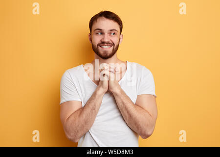 positive awesome man in white T-shirt thinking about something, new idea, close up photo. isolated blue background. gossip, curiosity. face expression Stock Photo