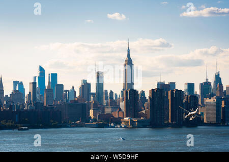 USA city, view of the central Manhattan skyline and waterfront with a seaplane descending to the East River,  New York City, USA. Stock Photo