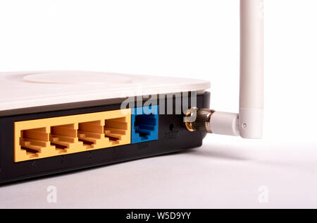 Black and white plastic router and antenna and blank connectors for internet and wifi network connection stand on white table. Stock Photo