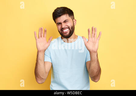 Handsome young emotional man denying, rejecting proposition, refusing bad deal offer. I'am sorry. close up portrait.isolated yellow background, studio Stock Photo