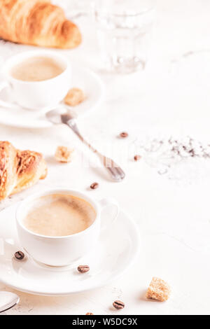 Traditional breakfast with fresh croissants on white background, vertical. Stock Photo