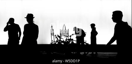 Belgrade, Serbia - July 23, 2019: Silhouettes of people walking in motion blur in the night, in high contrast black and white Stock Photo