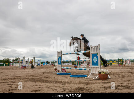 Carrigaline, Cork, Ireland. 28th July, 2019. Jamie Garland on Zeplepplin clears the final fence in the 1.5m New Height Champions Series during the Premier Grand Prix, 3-day event that was held at the Maryville Equestrian Centre in Carrigaline, Co. Cork, Ireland. Credit: David Creedon/Alamy Live News Stock Photo