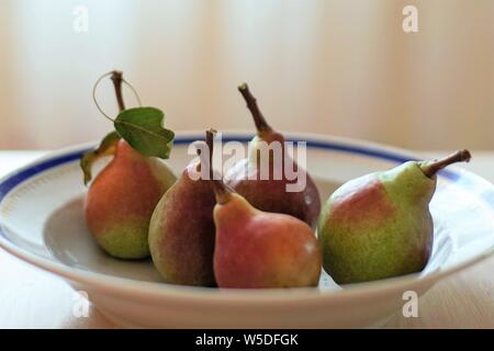 five ripe pear fruits in a deep plate close up Stock Photo
