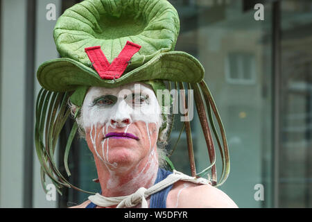 Glasgow, Scotland, UK. 28th July 2019. After heavy rain showers causing some entertainment to cancel, OCEANALLOVER, an international street entertainment theatre, took advantage of a brief respite in the rain and entertained the crowds in Brunswick Street with their play 'Transfigured'. Credit: Findlay/Alamy Live News Stock Photo